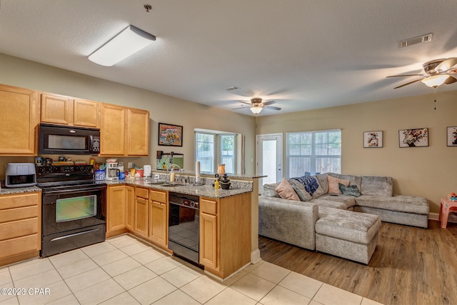 kitchen with light tile floors, ceiling fan, kitchen peninsula, and black appliances