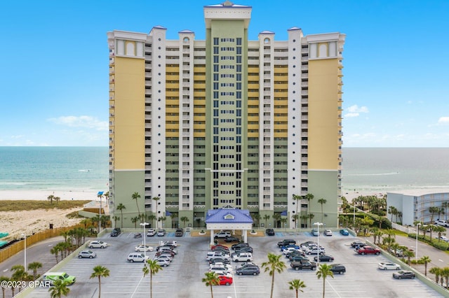 view of building exterior with a water view and a beach view