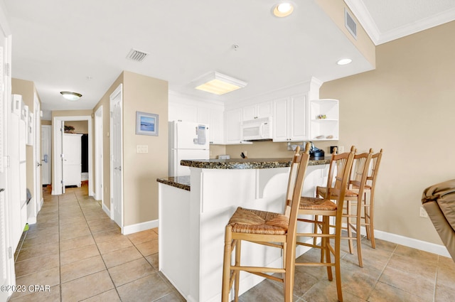 kitchen featuring a breakfast bar, white appliances, white cabinets, ornamental molding, and kitchen peninsula