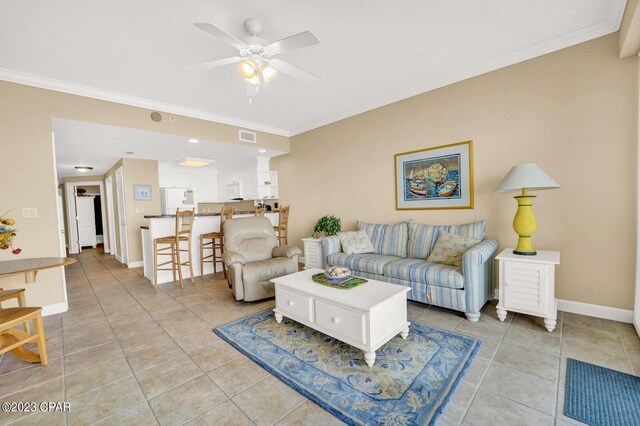 tiled living room with ceiling fan and crown molding