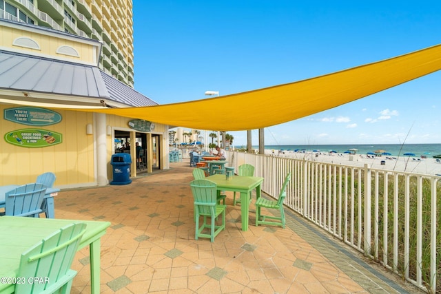 view of patio featuring a water view and a view of the beach