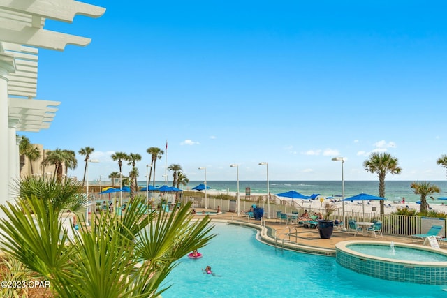 view of pool featuring pool water feature, a patio area, and a water view