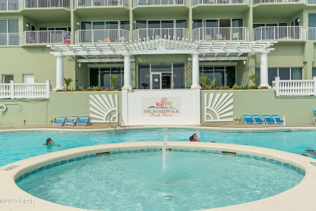 view of pool featuring a pergola and a hot tub