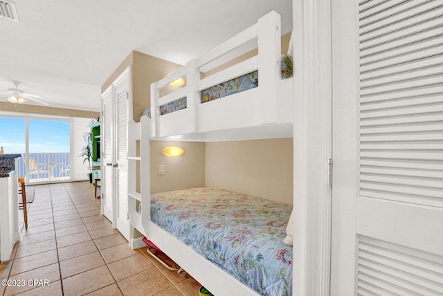 bedroom featuring a closet, ceiling fan, and light tile patterned flooring