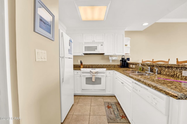 kitchen featuring white cabinetry, sink, dark stone countertops, white appliances, and light tile patterned floors