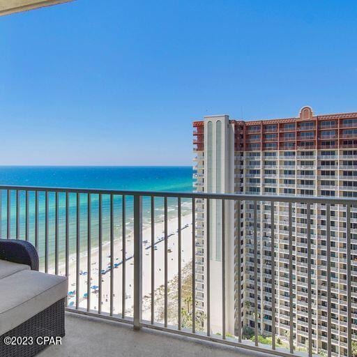 balcony featuring a water view and a beach view