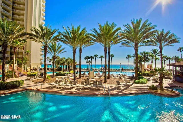 view of pool with a water view and a patio area