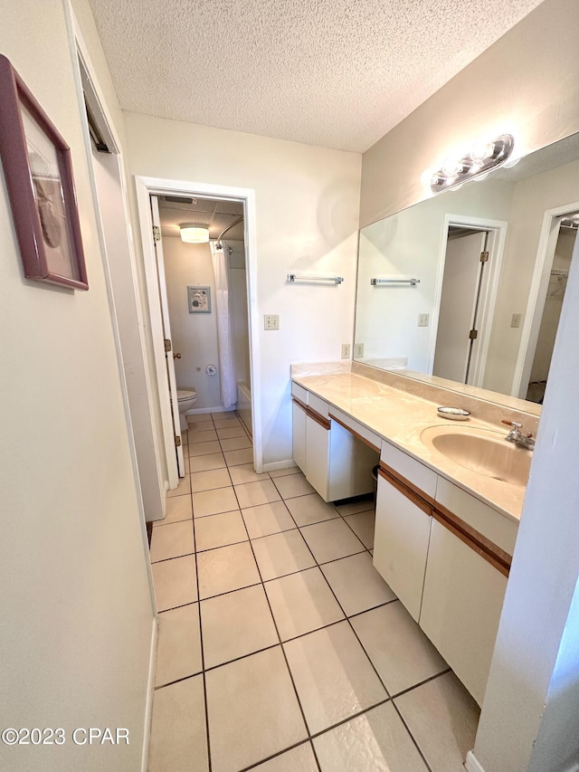 bathroom with toilet, tile flooring, a textured ceiling, and vanity