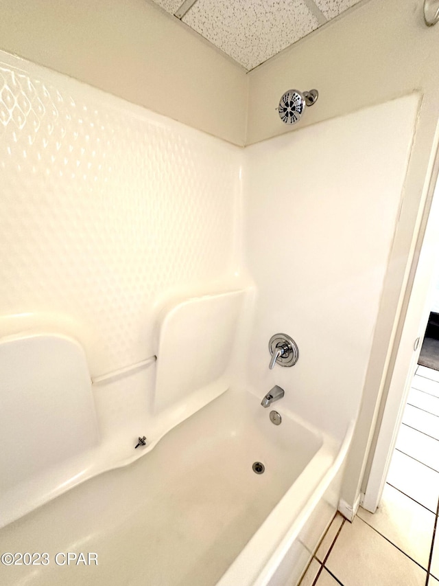 bathroom featuring tile flooring and bathing tub / shower combination