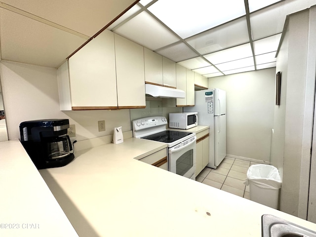 kitchen featuring light tile floors, white appliances, and white cabinetry