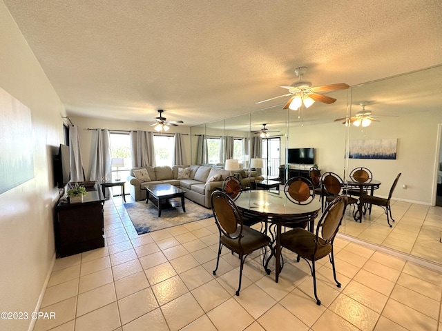 dining space featuring light tile flooring, ceiling fan, and a textured ceiling