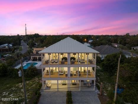 back house at dusk with a garage and a balcony