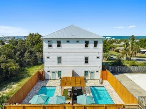 rear view of property with a fenced in pool and a patio