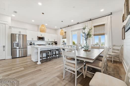 dining space with light hardwood / wood-style flooring and french doors