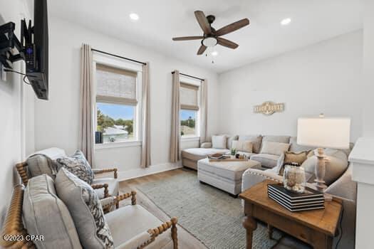 living room with hardwood / wood-style floors and ceiling fan