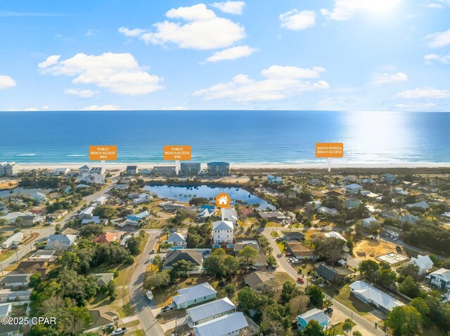 birds eye view of property with a water view and a beach view