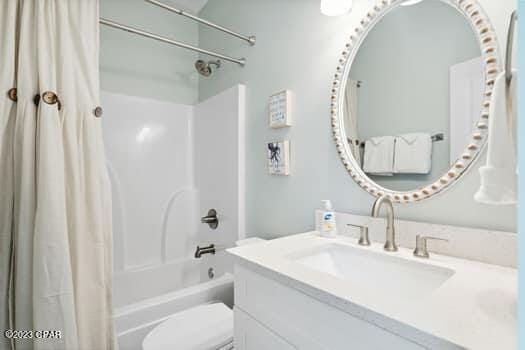 full bathroom with vanity, shower / tub combo, and toilet