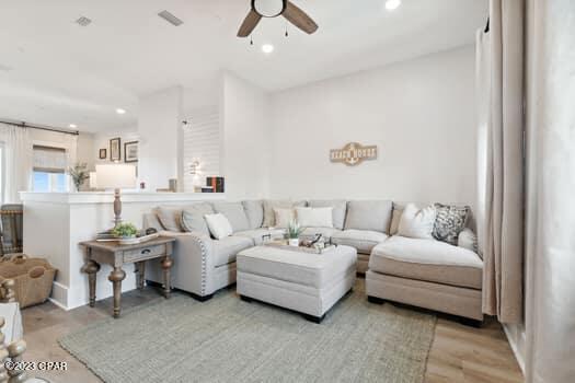 living room with light hardwood / wood-style floors and ceiling fan