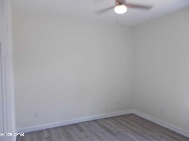 empty room featuring ceiling fan, baseboards, and wood finished floors