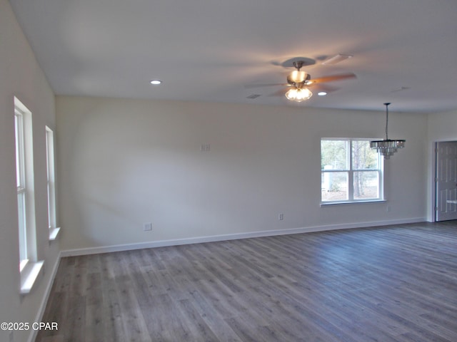 unfurnished room with recessed lighting, baseboards, wood finished floors, and ceiling fan with notable chandelier