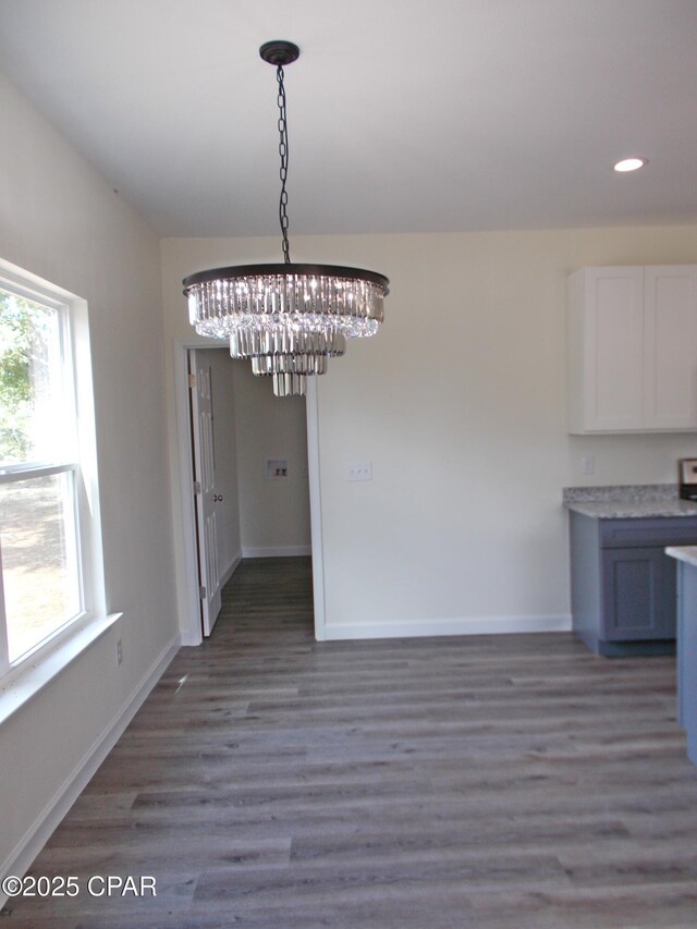 kitchen with white cabinetry, wood-type flooring, pendant lighting, a center island with sink, and appliances with stainless steel finishes