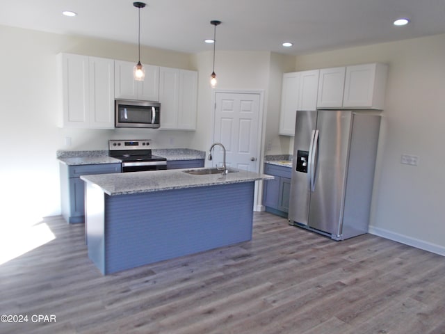 kitchen with sink, a center island with sink, appliances with stainless steel finishes, pendant lighting, and white cabinets