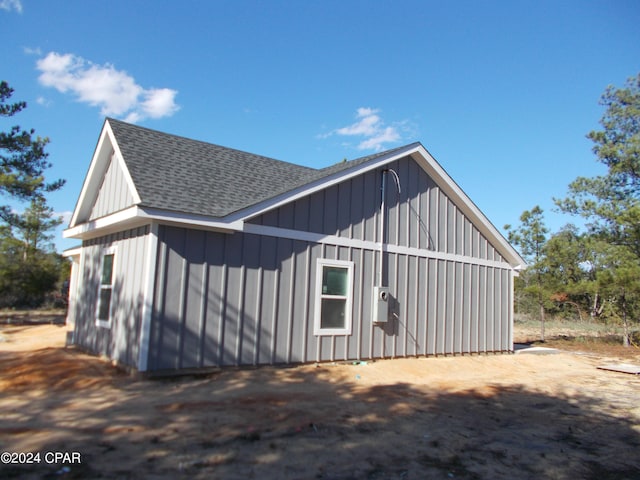 exterior space featuring a shingled roof and board and batten siding