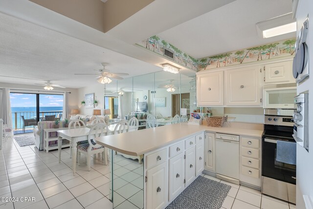 kitchen featuring kitchen peninsula, appliances with stainless steel finishes, white cabinets, and a water view