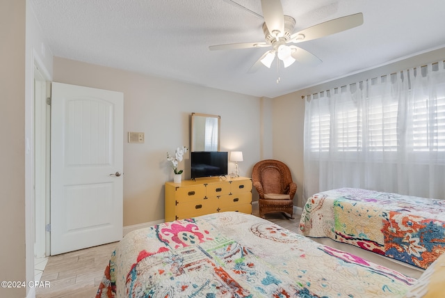 bedroom featuring a textured ceiling, light hardwood / wood-style floors, and ceiling fan