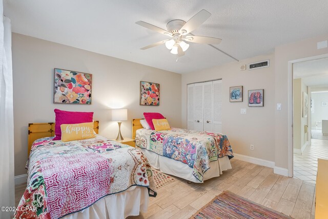 bedroom with light hardwood / wood-style floors, a closet, and ceiling fan