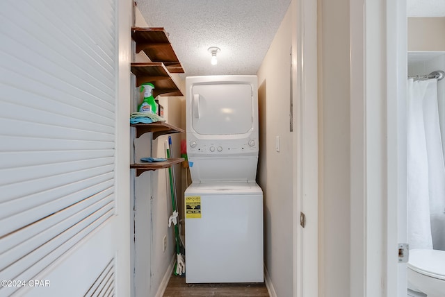 clothes washing area with a textured ceiling, stacked washing maching and dryer, and dark hardwood / wood-style floors