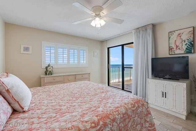 bedroom with access to exterior, ceiling fan, light hardwood / wood-style flooring, and a textured ceiling