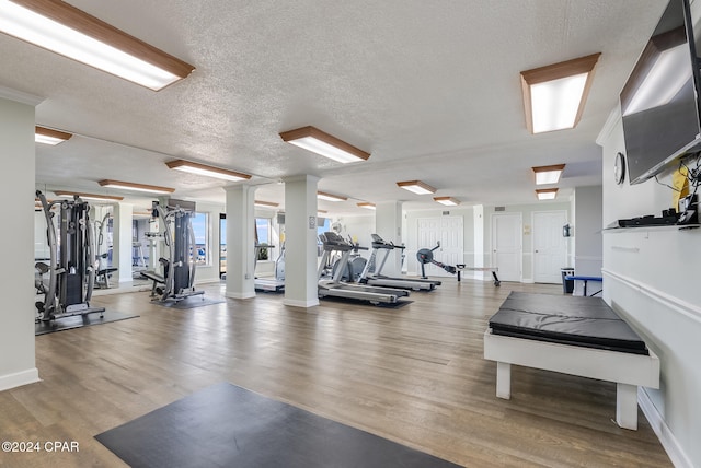 gym with wood-type flooring and a textured ceiling