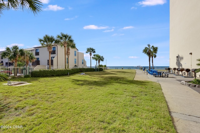 view of community with a lawn and a water view