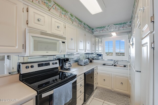 kitchen featuring sink, black dishwasher, light tile patterned flooring, stainless steel range with electric cooktop, and white cabinets