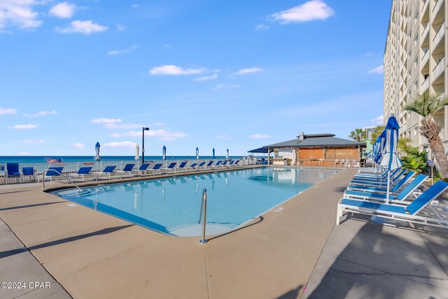 view of swimming pool featuring a patio area and a water view