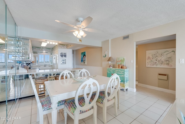 tiled dining area featuring ceiling fan and a textured ceiling