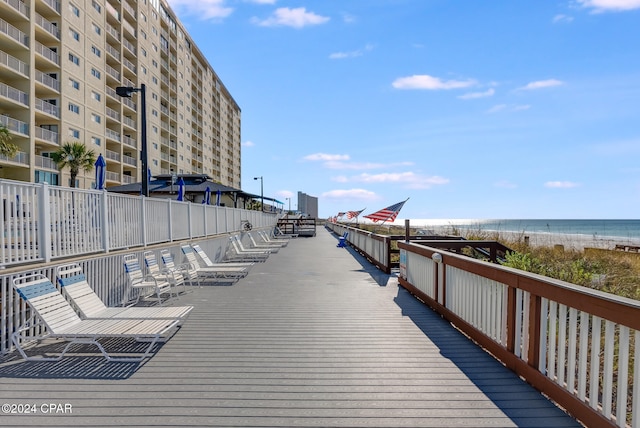 dock area featuring a water view and a beach view