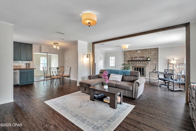 living room featuring a fireplace, a textured ceiling, and dark hardwood / wood-style floors