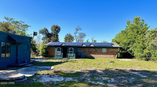 back of house featuring solar panels and a yard