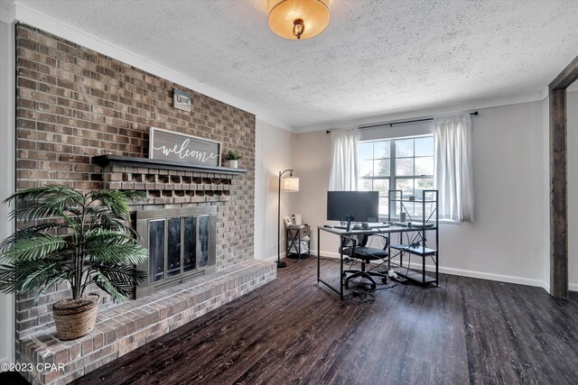 office area featuring dark wood-type flooring, a textured ceiling, and a brick fireplace