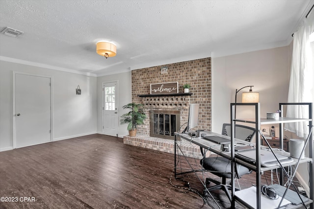 office area featuring dark hardwood / wood-style flooring, crown molding, a fireplace, and a textured ceiling