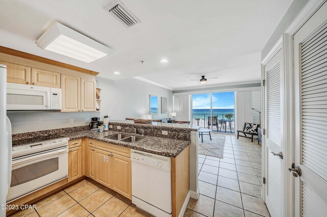 kitchen with white appliances, kitchen peninsula, light tile patterned floors, ceiling fan, and sink