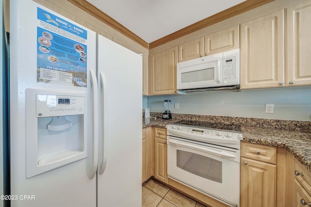 kitchen with white appliances, dark stone countertops, light brown cabinetry, and light tile patterned floors