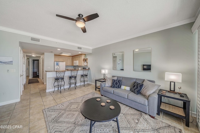 tiled living room with ceiling fan, a textured ceiling, and crown molding