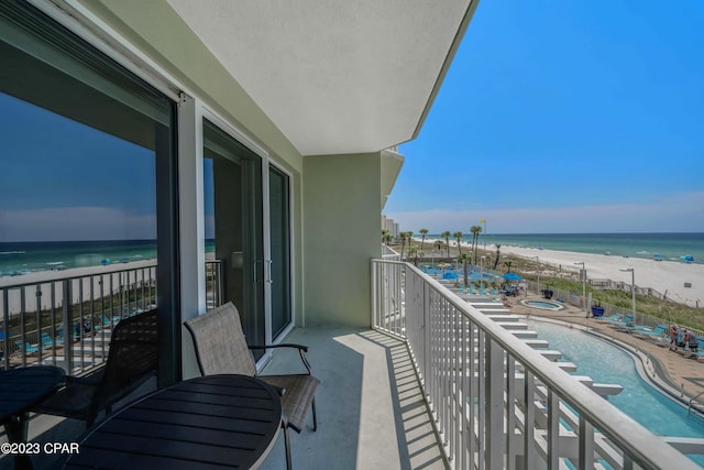 balcony featuring a beach view and a water view