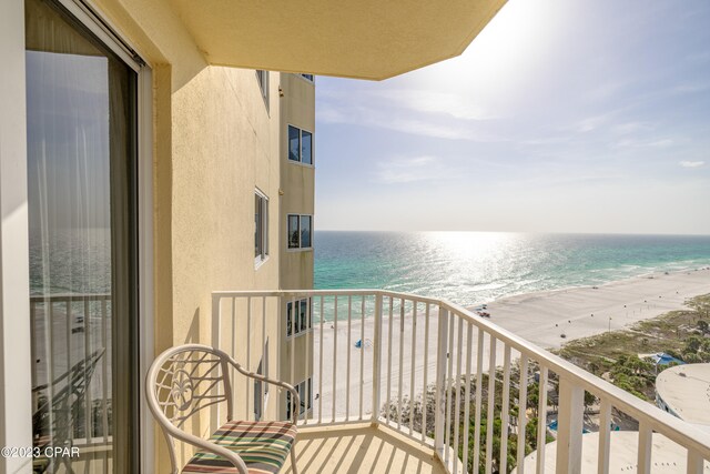 balcony featuring a water view and a beach view