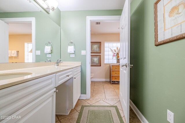 bathroom featuring vanity, tile patterned flooring, and toilet