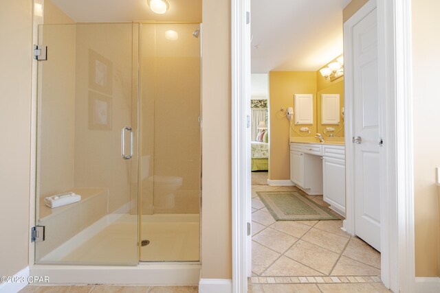 bathroom with sink, a shower with door, and tile patterned floors