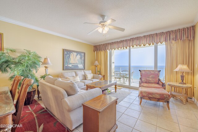 living room with a textured ceiling, light tile patterned flooring, a water view, crown molding, and ceiling fan